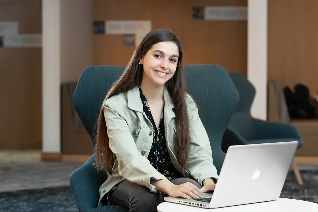 Sofia de la Grana smiling and working on a computer.